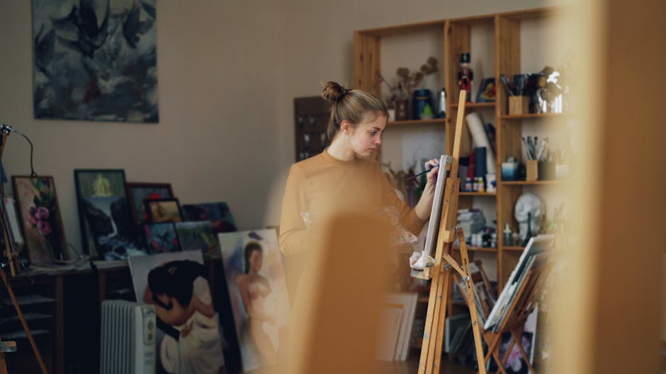 Young artist painting on canvas in a cozy and creative studio setting.