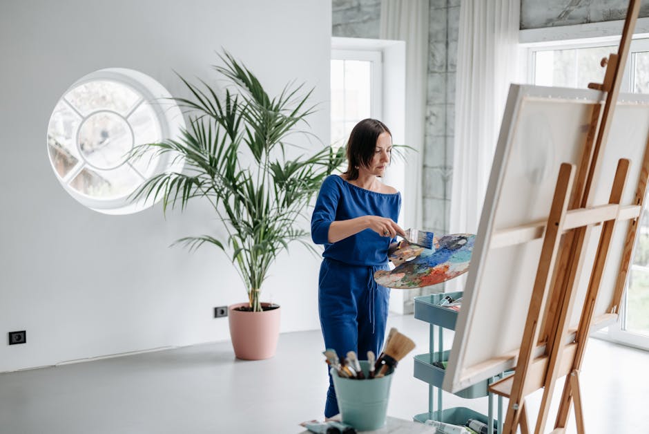A female artist working on a canvas in a modern art studio with natural light.