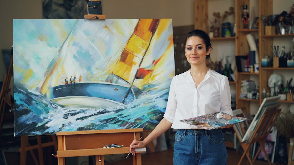 Artist in a studio showcasing a colorful sailing painting on an easel.
