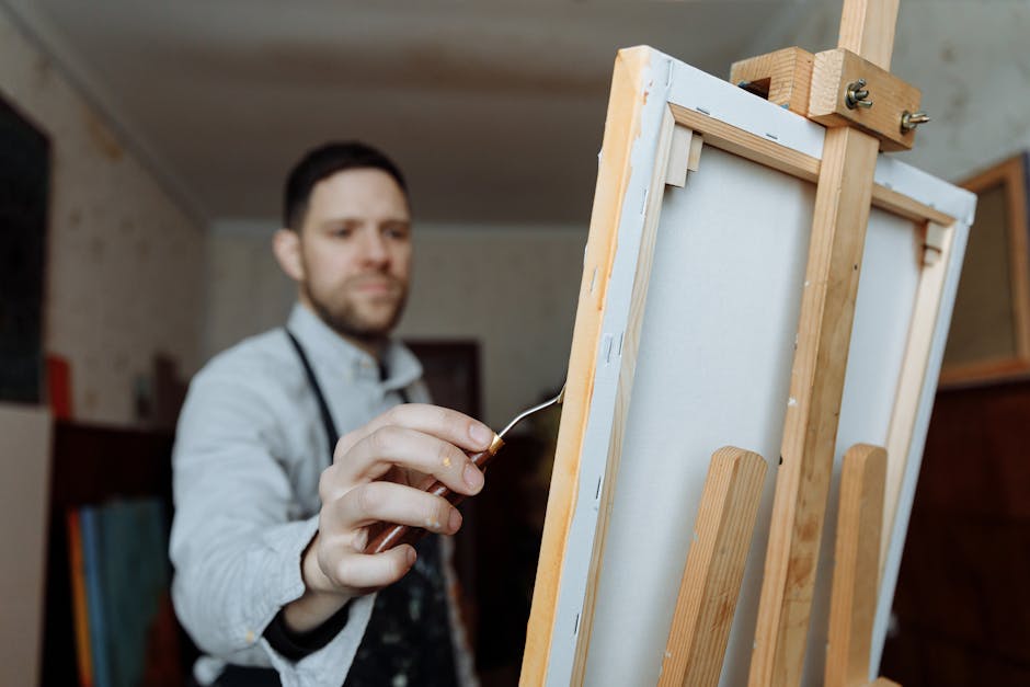Artist in studio painting on canvas, showcasing creativity and passion.